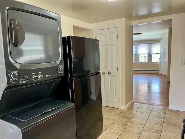 a view of a livingroom with wooden floor and a refrigerator