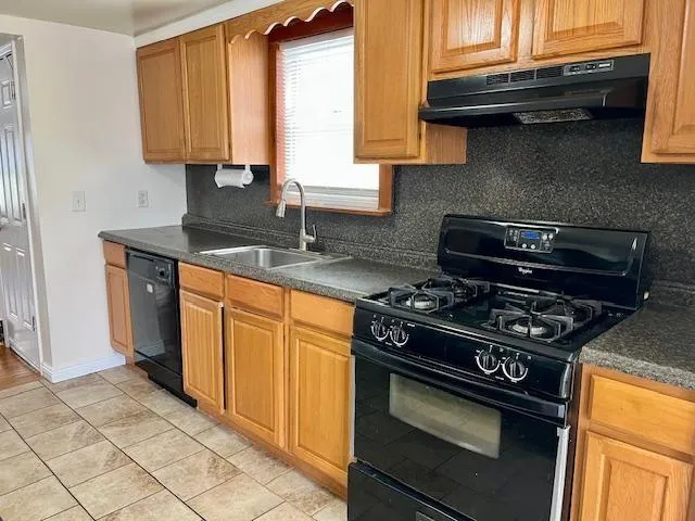 a kitchen with granite countertop a stove and a sink