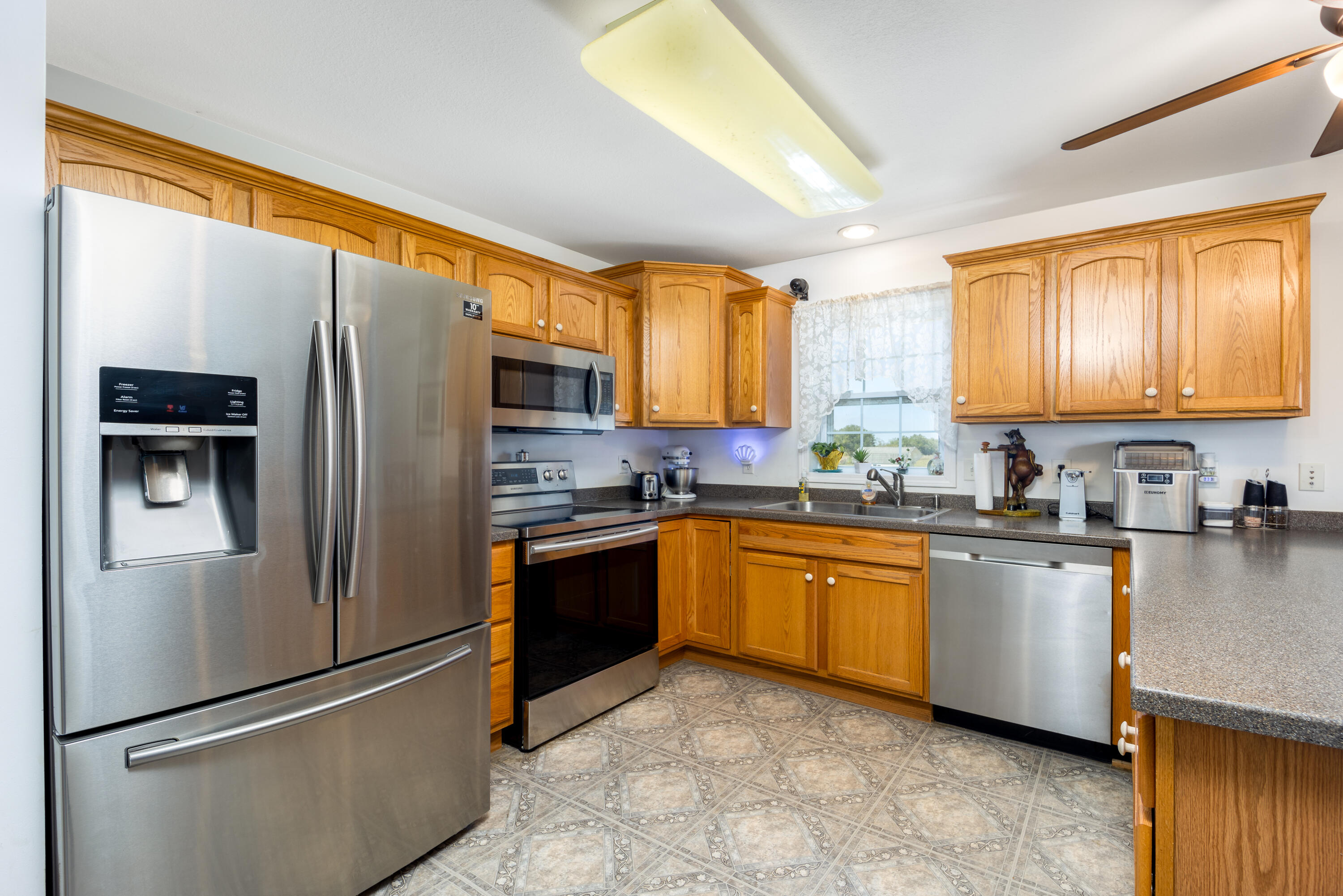 1101 Trowbridge Road Fort Pierce, FL 34945 - Photo 28 of 38 a kitchen with stainless steel appliances granite countertop a refrigerator stove a sink dishwasher and microwave