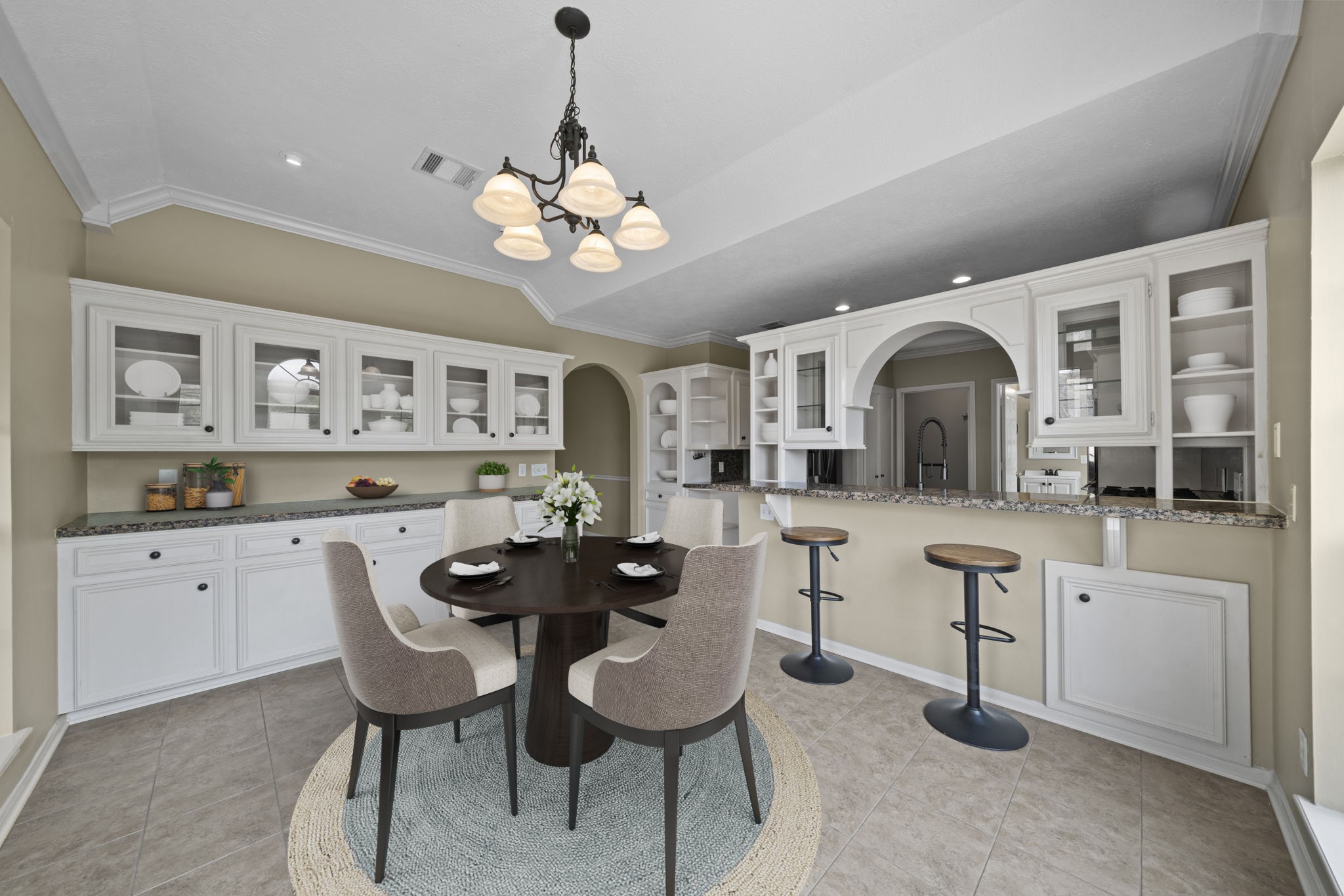 169 April Cove Montgomery, TX 77356 - Photo 21 of 39 Virtually Staged: Cozy breakfast nook located just off the kitchen, featuring built-in cabinetry, a serving breakfast bar with seating, and elegant lighting overhead. This inviting space offers the perfect setting for casual dining and morning coffee while staying connected to the heart of the home.