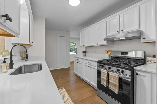 a kitchen with granite countertop a stove sink and cabinets