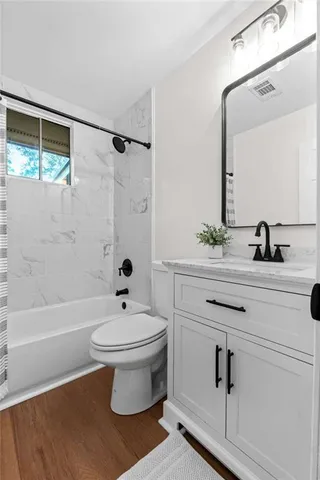 a bathroom with a sink a toilet a mirror and shower