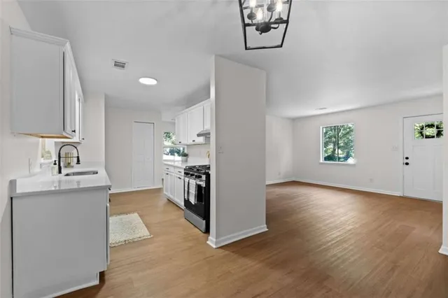 a view of a kitchen with sink and wooden floor