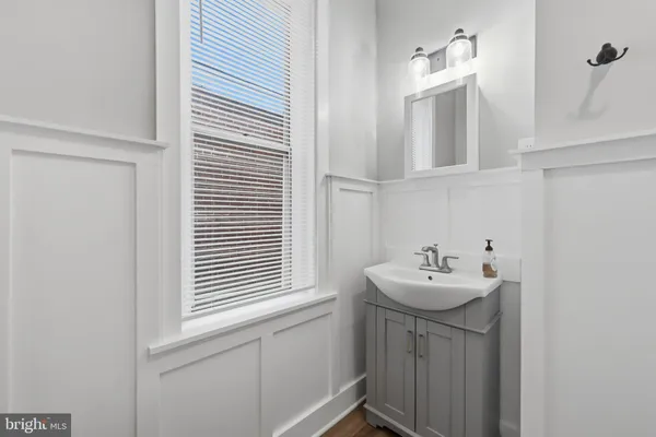 a bathroom with a sink a mirror and a window