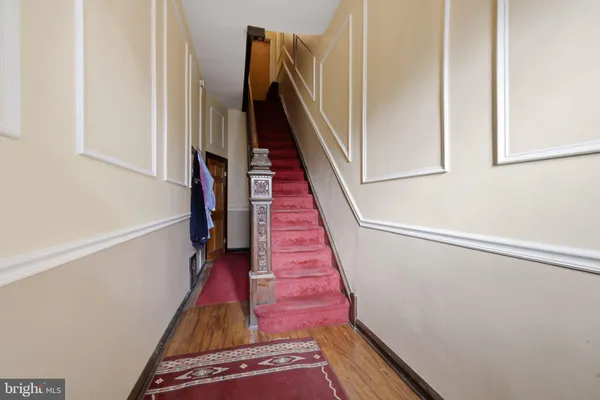 a view of a hallway with wooden floor and stairs