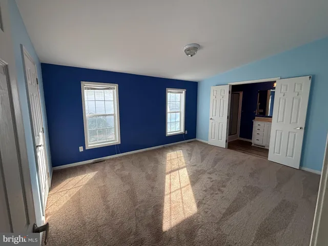 an empty room with windows and closet