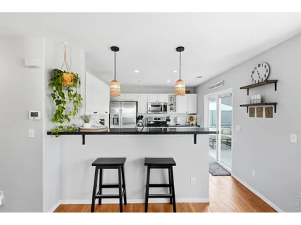 a kitchen with stainless steel appliances granite countertop a table chairs and a refrigerator