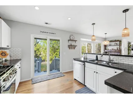 a kitchen with stainless steel appliances granite countertop a sink a stove a counter space and cabinets