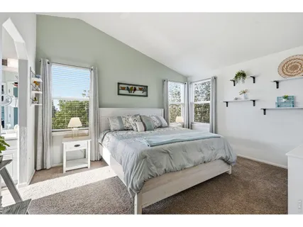 a spacious bedroom with a bed and a painting on the wall