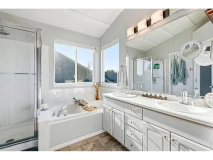 a bathroom with a tub sink and mirror