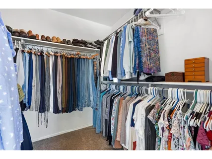 a view of walk in closet with clothes and shoes