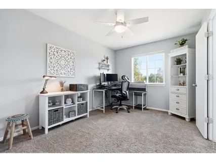 a view of a workspace with furniture and a window