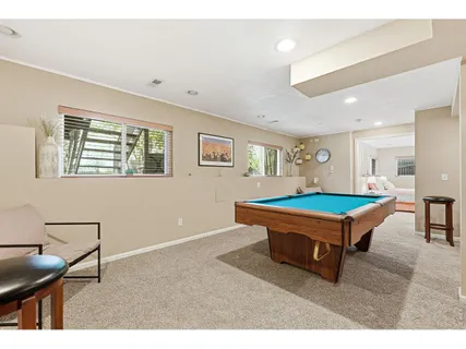 a room with furniture pool table and window