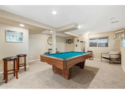 a room with furniture pool table and windows