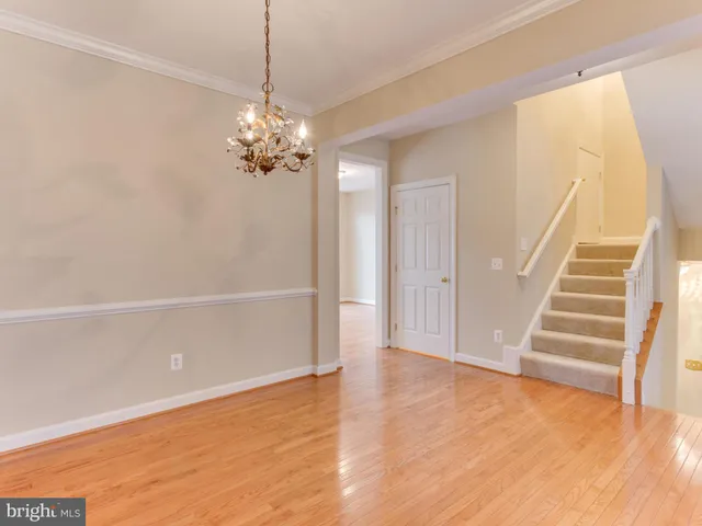 a view of a room with wooden floor and ceiling fan