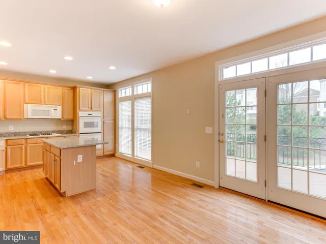 a large kitchen with stainless steel appliances granite countertop a large window a oven and a sink