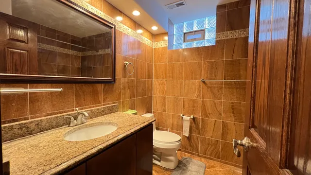 a bathroom with a granite countertop sink toilet and shower