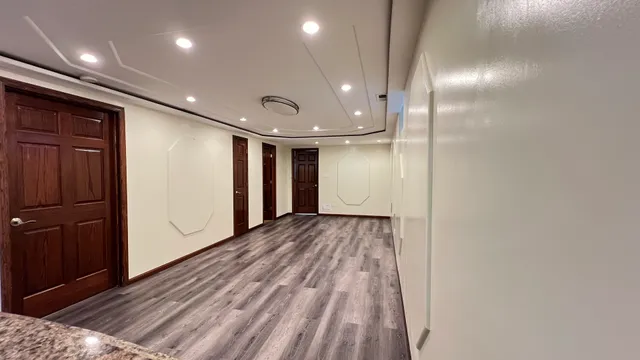 a view of a room with a large window and wooden floor