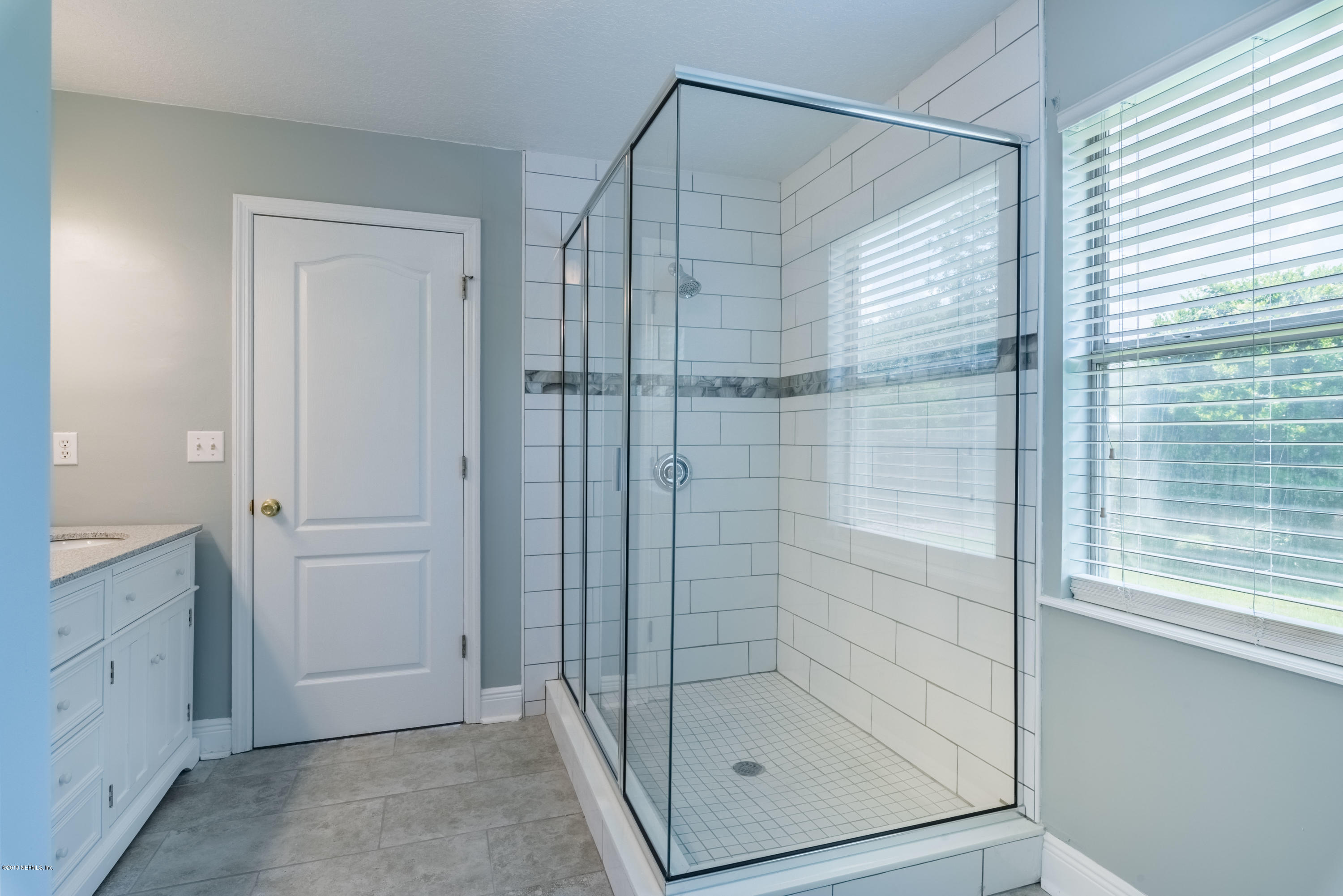 10368 Sugar Grove Road Jacksonville, FL 32221 - Photo 16 of 28 a bathroom with a glass shower door
