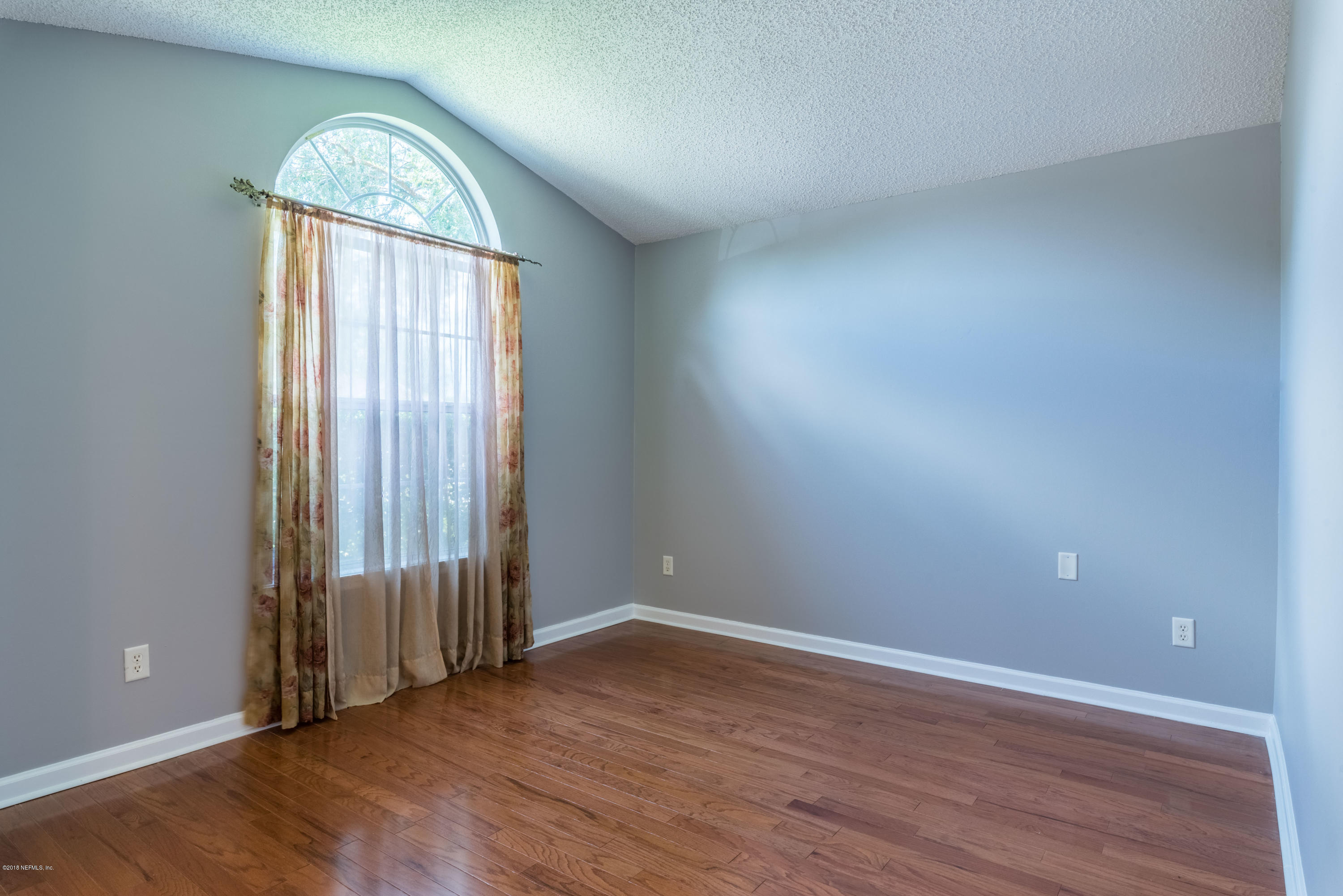 10368 Sugar Grove Road Jacksonville, FL 32221 - Photo 5 of 28 an empty room with wooden floor mirror and windows
