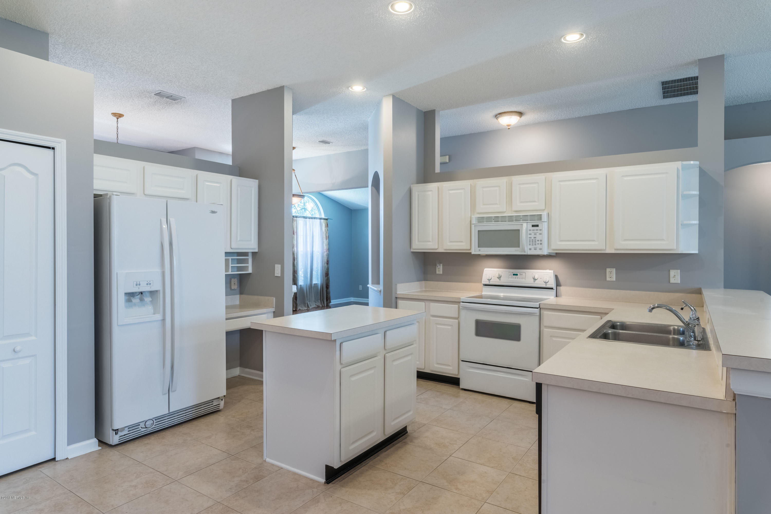 10368 Sugar Grove Road Jacksonville, FL 32221 - Photo 6 of 28 a kitchen with white cabinets and stainless steel appliances