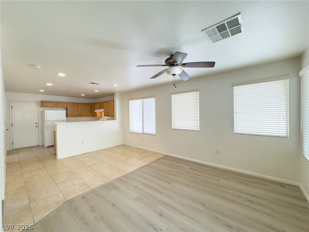 9456 Grandview Spring Avenue Las Vegas, NV 89166 - Photo 9 of 49 An open concept living area transitions to the kitchen, featuring mixed flooring and well-lit interiors.