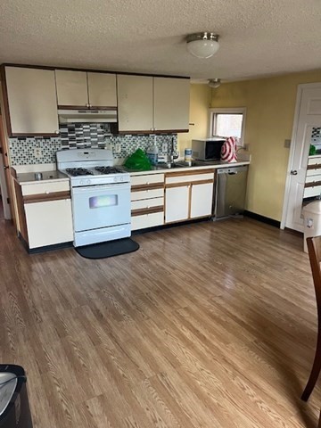 291 Broadway, Unit D Haverhill, MA 01832 - Photo 6 of 10 a kitchen with stainless steel appliances a sink and a stove