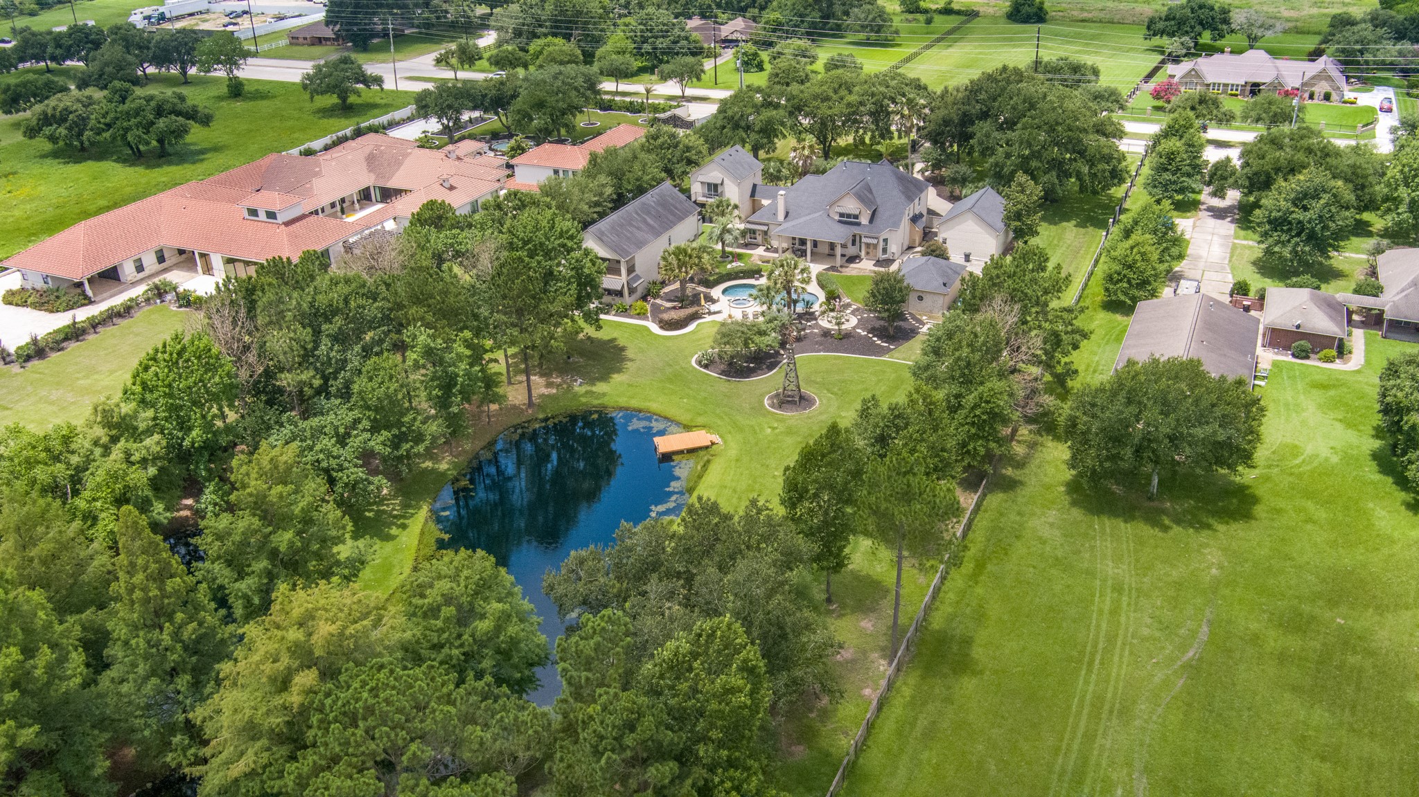 13914 Skinner Road Cypress, TX 77429 - Photo 4 of 50 Private backyard oasis featuring a scenic pond with its own dock, resort style pool and spa, lush landscaping, mature trees, and expansive grounds designed for relaxing and entertaining.