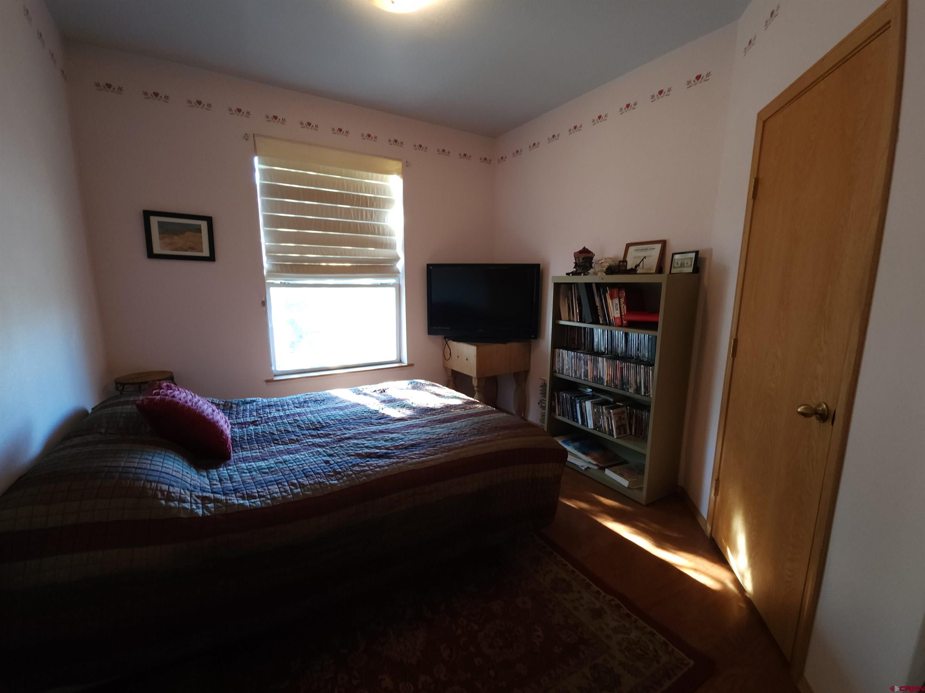 323 Holiday Overlook Crestone, CO 81131 - Photo 7 of 30 a bedroom with a bed and a book shelf