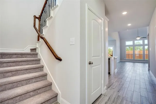 a view of a hallway with wooden floor and staircase