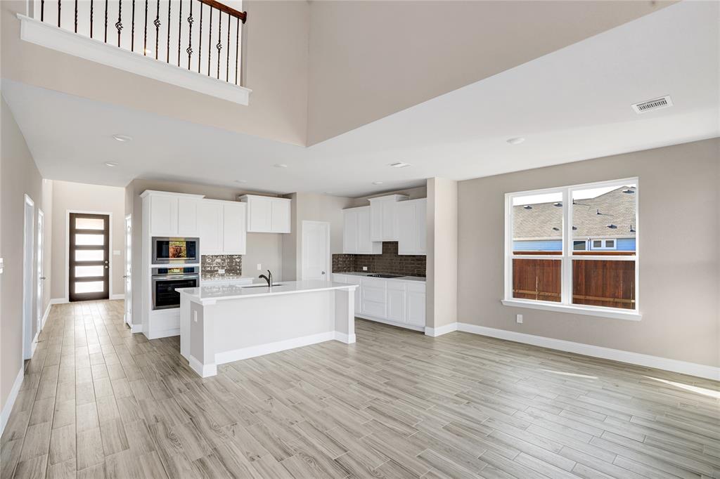 8526 Royal Star Road Rowlett, TX 75089 - Photo 4 of 21 a kitchen with a wooden floor a sink and a stove top oven