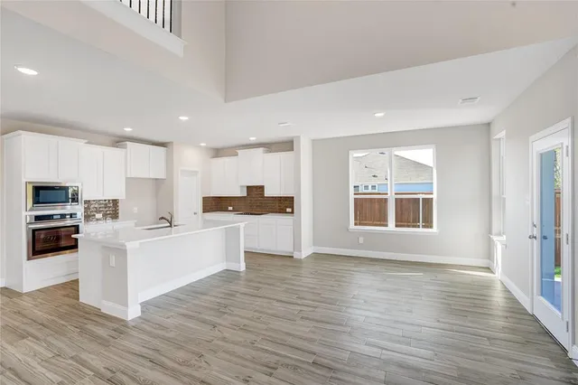 a kitchen with stainless steel appliances a refrigerator and a stove top oven