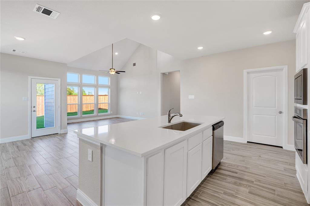8526 Royal Star Road Rowlett, TX 75089 - Photo 8 of 21 a kitchen with stainless steel appliances granite countertop a sink and wooden floors