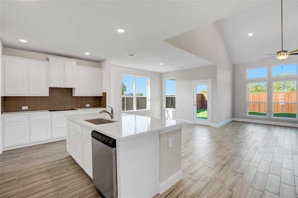8526 Royal Star Road Rowlett, TX 75089 - Photo 9 of 21 a kitchen with granite countertop a stove top oven a sink a counter space and cabinets