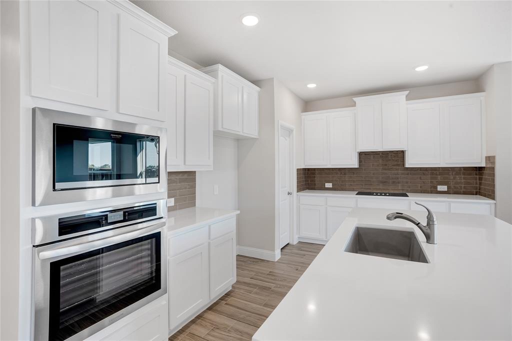 8526 Royal Star Road Rowlett, TX 75089 - Photo 10 of 21 a kitchen with granite countertop white cabinets and stainless steel appliances