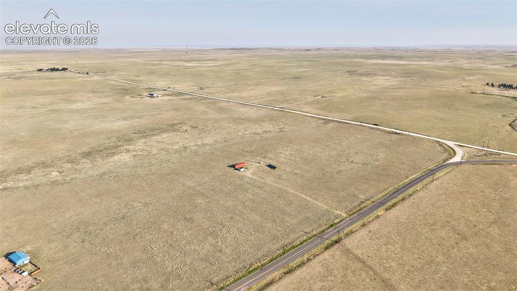 9670 Boone Road Yoder, CO 80864 - Photo 8 of 18 Expansive undeveloped land with a partial paved road frontage and a dirt road intersection