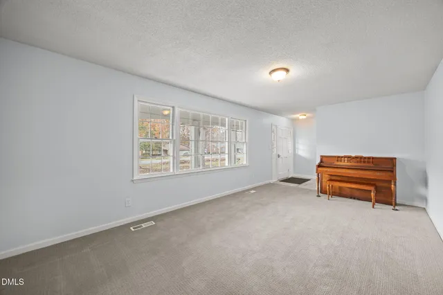 a view of empty room with air conditioner duct and window