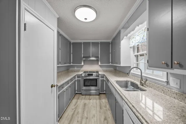 a kitchen with stainless steel appliances granite countertop a sink stove and cabinets