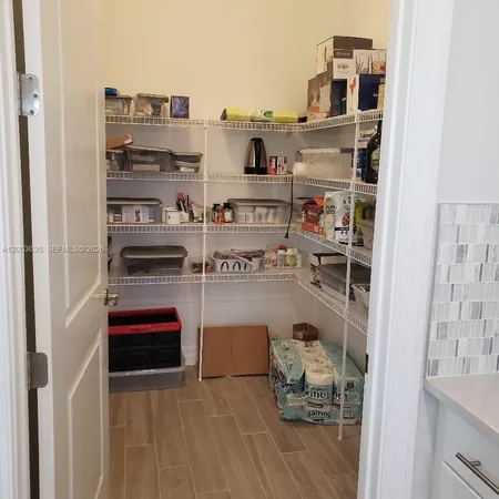 a utility room with stainless steel appliances granite countertop a sink and a white cabinets