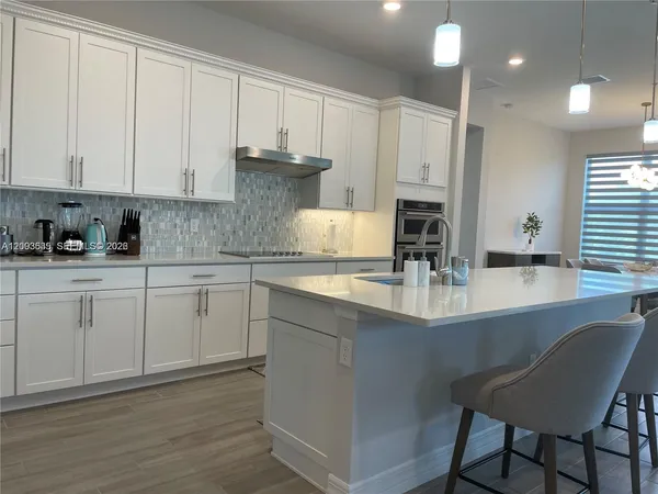a kitchen with a dining table chairs sink and cabinets