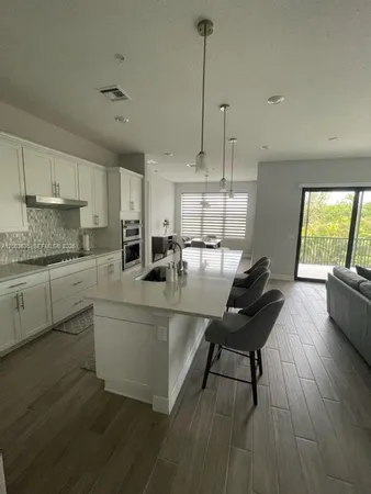 a kitchen with kitchen island a sink stainless steel appliances and cabinets