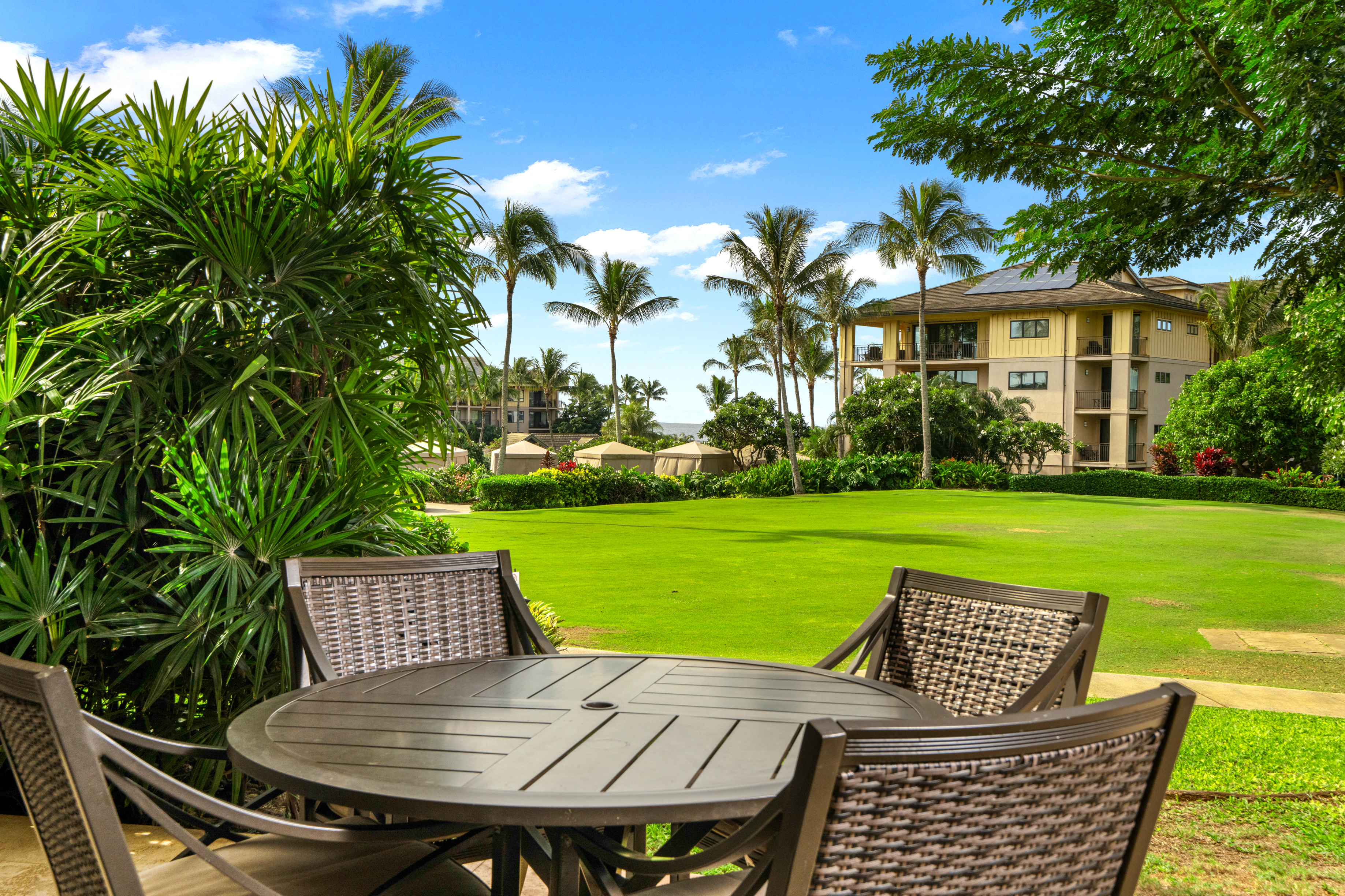 2641 Poipu Road, Unit 1107 Koloa, HI 96756 - Photo 16 of 22 a view of a patio with table and chairs with plants and trees