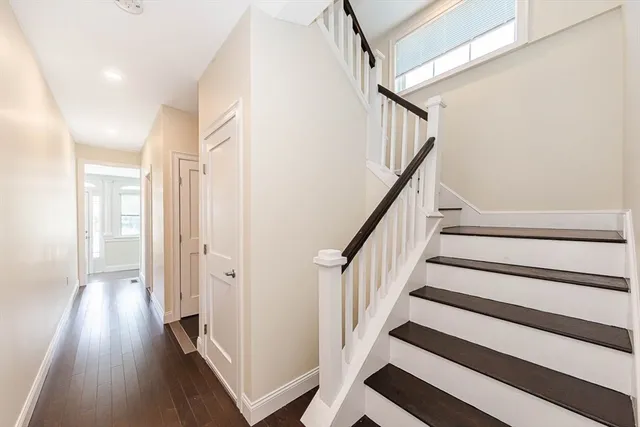 a view of a hallway with wooden floor and staircase