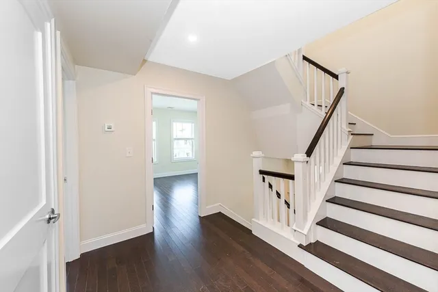 a view of a hallway with wooden floor and staircase