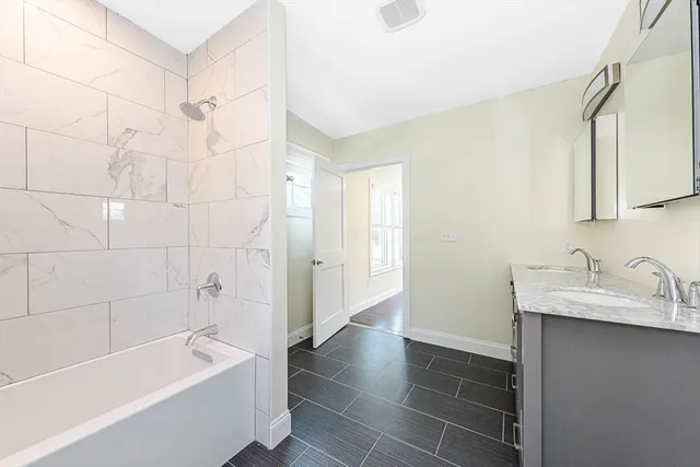 a bathroom with a tub sink and a mirror