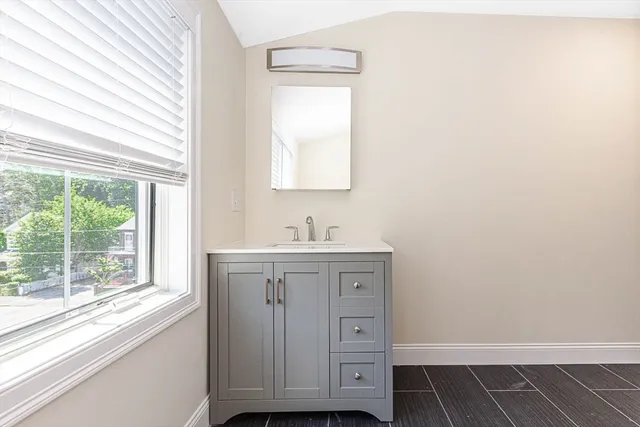a bathroom with a sink a mirror and a window
