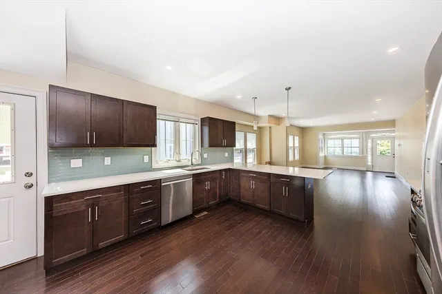 a large kitchen with wooden floors and stainless steel appliances