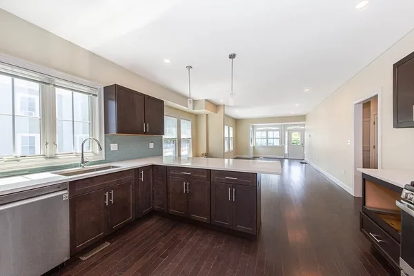 a large kitchen with wooden floors and stainless steel appliances