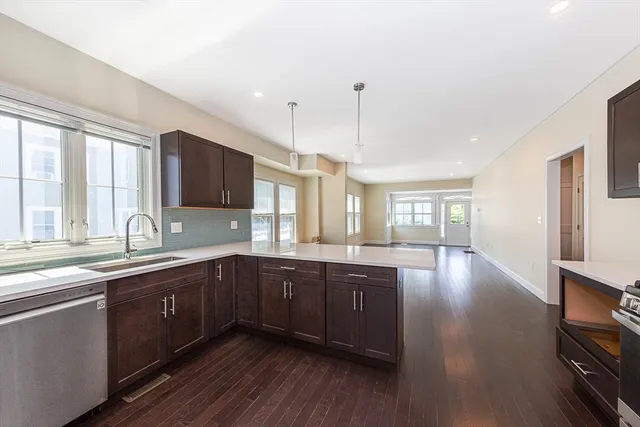 a large kitchen with wooden floors and stainless steel appliances