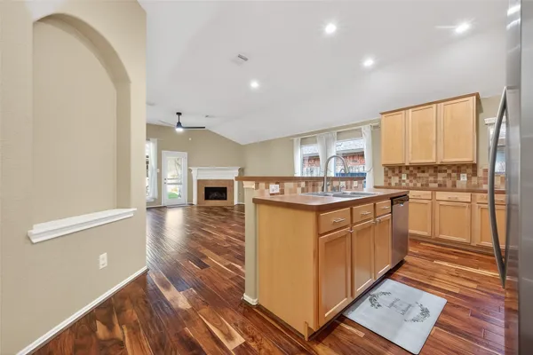 a kitchen with stainless steel appliances granite countertop a refrigerator a stove and a wooden floors